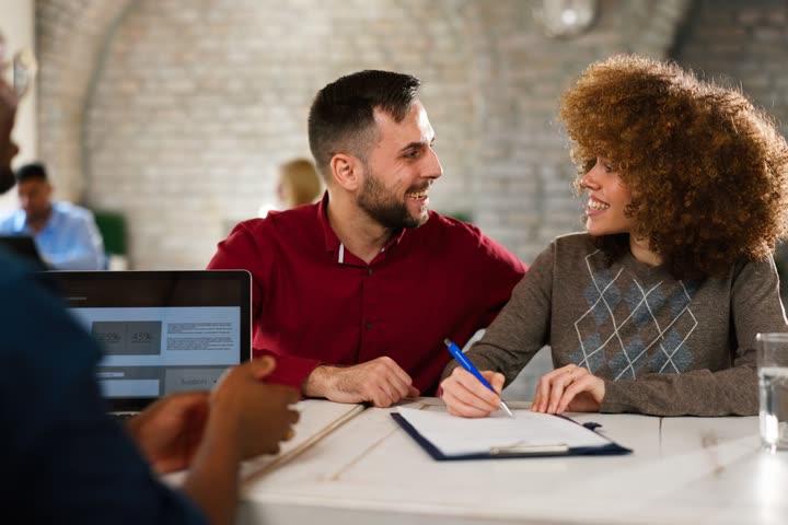 Professional guiding buyers through documents at a signing appointment